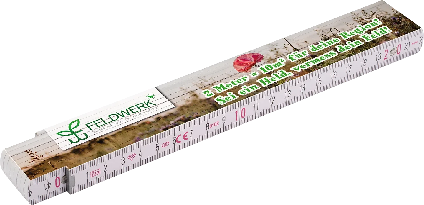 Feldwerk-Zollstock mit Mohnblumen-Panorama und dem Slogan: 2 Meter = 10 Quadratmeter für deine Region – sei ein Held, vermess dein Feld!