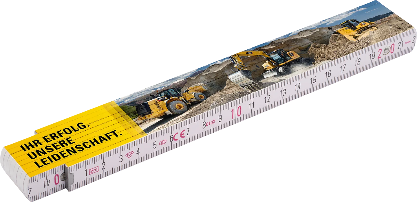 Zollstock für Zeppelin Baumaschinen mit CAT-Maschinen-Panorama und dem Slogan: Ihr Erfolg. Unsere Leidenschaft.